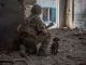 Украинский военный с щенком осматривает местность в промышленной части Северодонецка, 20 июня 2022 года. Фото: Oleksandr Ratushniak / Reuters